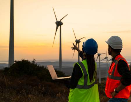 renewable wind turbines with two people pointing at them