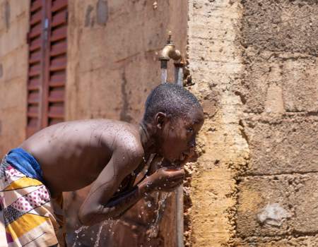 Boy drinking from water